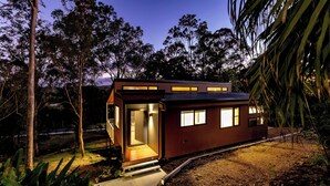 Une maison moderne avec une façade en bois, une porte bien visible et un petit porche.