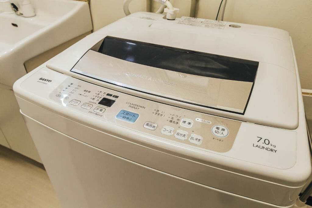 Vista frontale di una lavatrice compatta bianca, con pannello di controllo digitale e capacità di 7,0 kg.