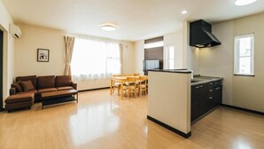 Um apartamento moderno com sala de estar, espaço para refeições e cozinha.