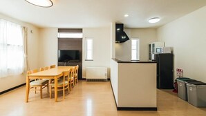 Uma cozinha compacta com área de refeições, fogão embutido e micro-ondas.