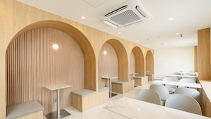 Un restaurante moderno con paneles de madera, nichos arqueados y un diseño limpio y minimalista.