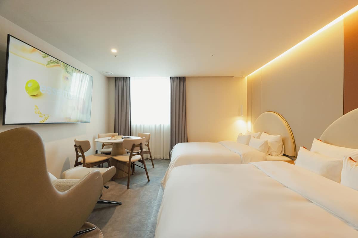 Una habitación de hotel con dos camas, un escritorio y una silla.