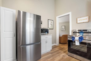 Cozinha moderna com eletrodomésticos de aço inoxidável, micro-ondas e forno Samsung.