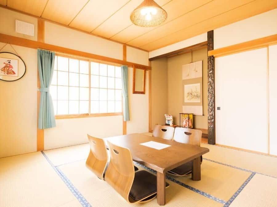 A traditional Japanese room with tatami flooring, a wooden table, and sliding doors.