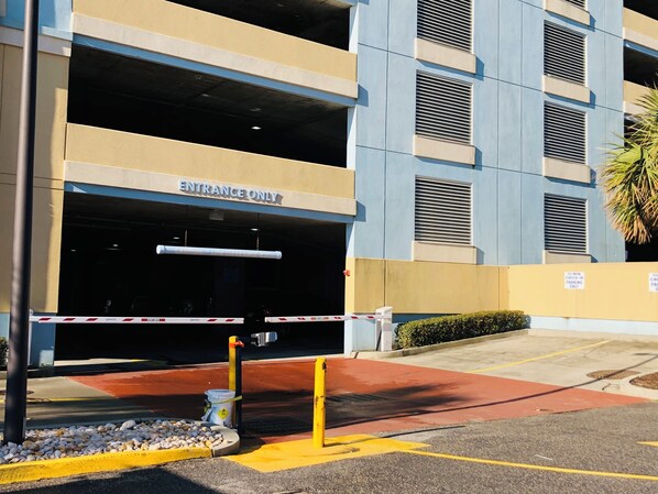 A multi-story parking garage entrance with a 'Entrance Only' sign, a 15-minute parking limit, and a gated access point.