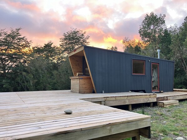 A modern cabin with a sloped roof and a small porch area.