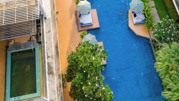 A multi-level hotel with a central swimming pool, multiple balconies, and lush greenery. - Luxury Residence Klong Muang Beach Krabi (Krabi)