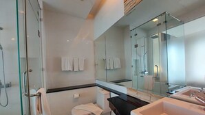 A modern bathroom with a glass shower enclosure, a white toilet, a large mirror, and a black countertop. - Luxury Residence Klong Muang Beach Krabi (Krabi)