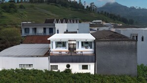 Un bâtiment moderne doté d’un toit plat, de grandes fenêtres et d’un balcon aménagé avec des sièges.