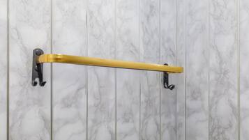 Ein Badezimmer mit Marmorwand und einem goldfarbenen Handtuchhalter.
