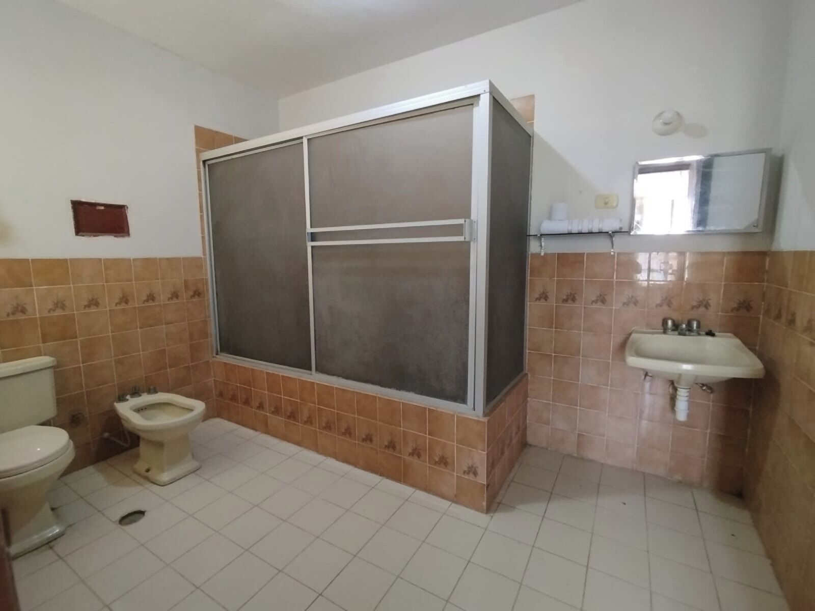 Un baño con inodoro, bidé y lavabo.