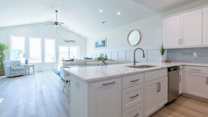 A spacious kitchen with a large island, white cabinetry, and a ceiling fan. - 4bedroom,5bed,4bath, elevator, ocean views and golf cart (Surf City)