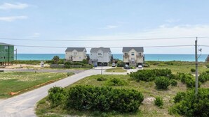 A coastal residential area with three houses, a road, and a view of the ocean. - 4bedroom,5bed,4bath, elevator, ocean views and golf cart (Surf City)