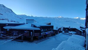 A snow-covered building with signage for a supermarket and ski rental services. - Magnificent 3-room apartment 31m², south-east facing, mountain/resort view (VAL THORENS)