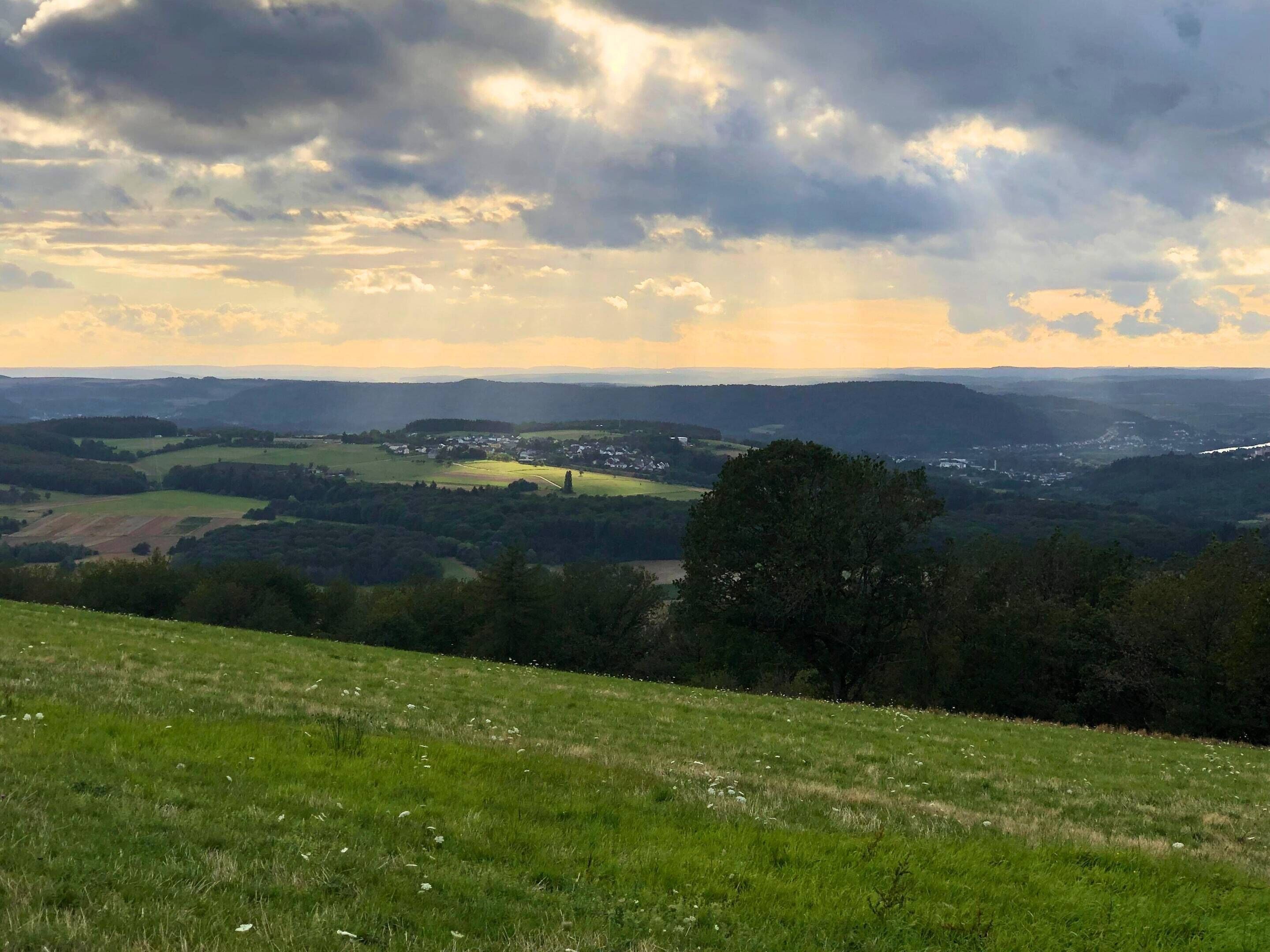 Ein weiter Panoramablick auf eine hügelige Landschaft mit einem Dorf im Tal.