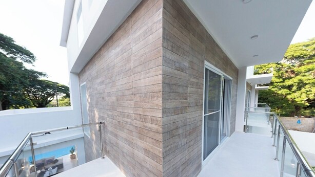 A modern building with a glass door and a balcony with metal railings. - FANTASTIC CARAIBIC VILLA in the heart of the Caribbean in the midst of nature (Sosúa)