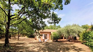 A rustic house with a tiled roof, surrounded by trees and a dry lawn. - Au coeur des ocres - Charming vacation home (Roussillon)
