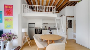 A modern kitchen with white cabinets, a built-in oven, and a refrigerator.
