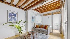 A modern living room with a sofa, a coffee table, and a large plant.