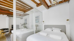 A modern bedroom with a large bed, a desk, and a chair.