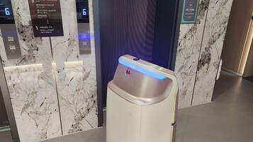 Ein Aufzug mit digitaler Anzeige für die 6. Etage, einem Schild für Gästezimmer und einem Check-in-Schild.