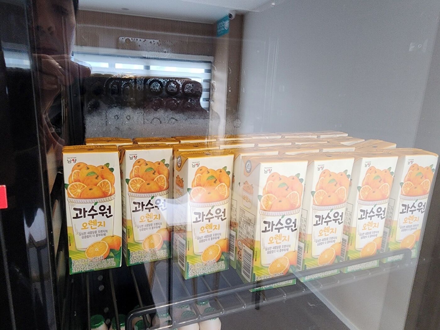 Un présentoir réfrigéré contenant plusieurs cartons de jus d’orange.