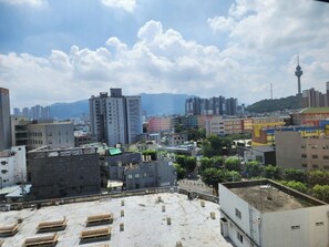 A cityscape with various buildings, including a prominent tower and a flat-roofed area with some structures.