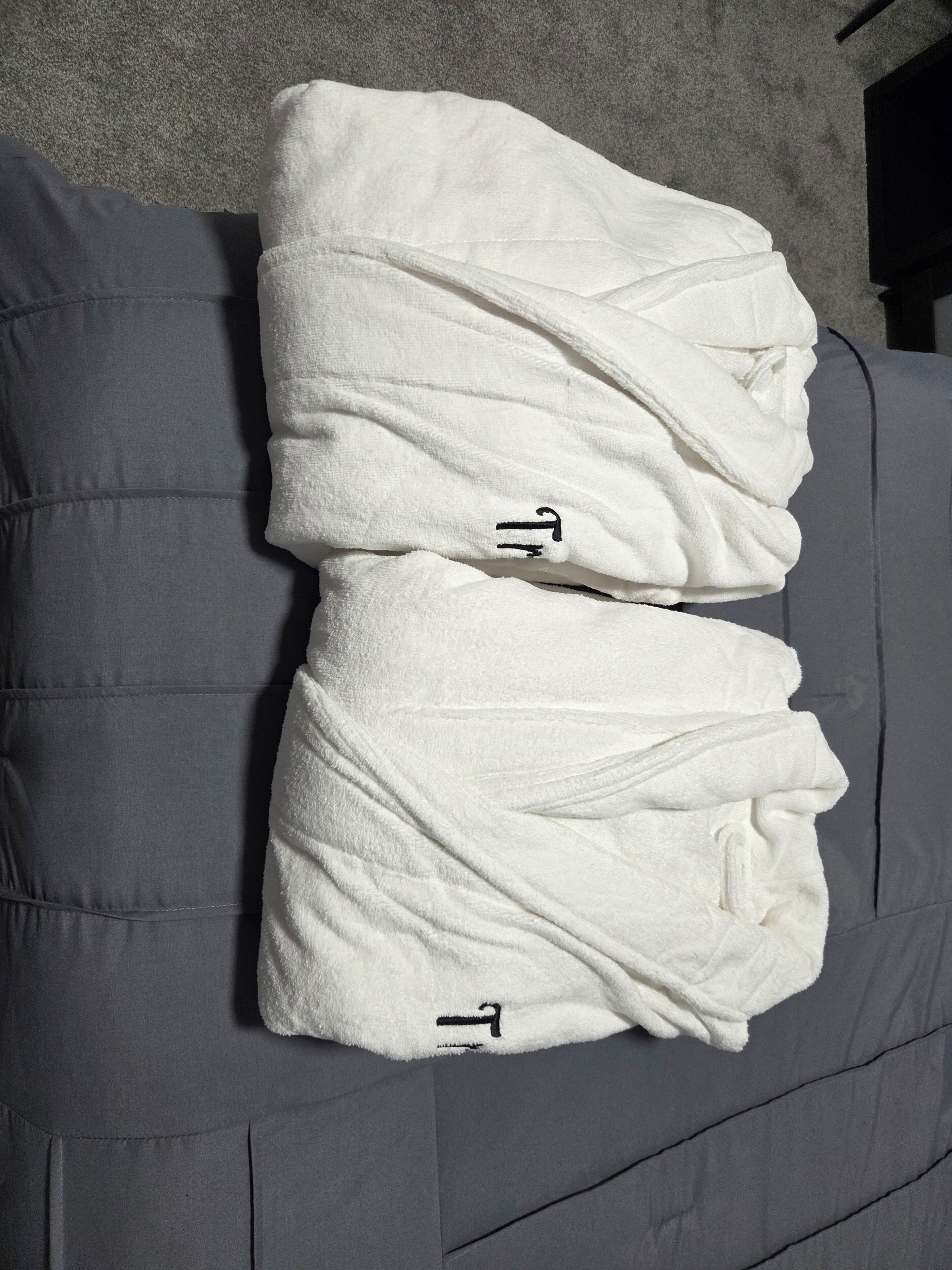 Un canapé gris sur lequel sont posées deux serviettes blanches.