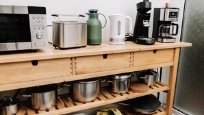 A kitchen counter with various appliances and cookware.