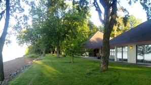 A modern building with a sloped roof, large windows, and a well-maintained lawn.