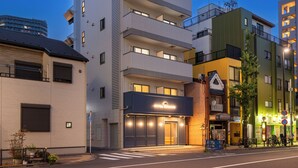 A hotel with a modern facade, multiple balconies, and a visible entrance. - HOTEL KOMACHI Higashi Nippori (Tokyo)