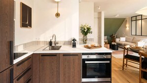 A modern kitchen with a built-in oven, a sink, and a coffee machine.