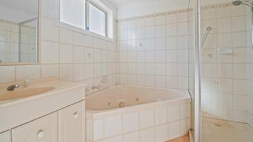 Une salle de bain avec une baignoire, une douche et un lavabo.