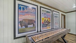 Une pièce dont les murs sont ornés de posters encadrés, avec une table d’exposition en bois et un lambris en bois au plafond.