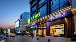 A hotel with a modern facade, large windows, and a prominent entrance. - Huiyue Hotel  (Chengdu)