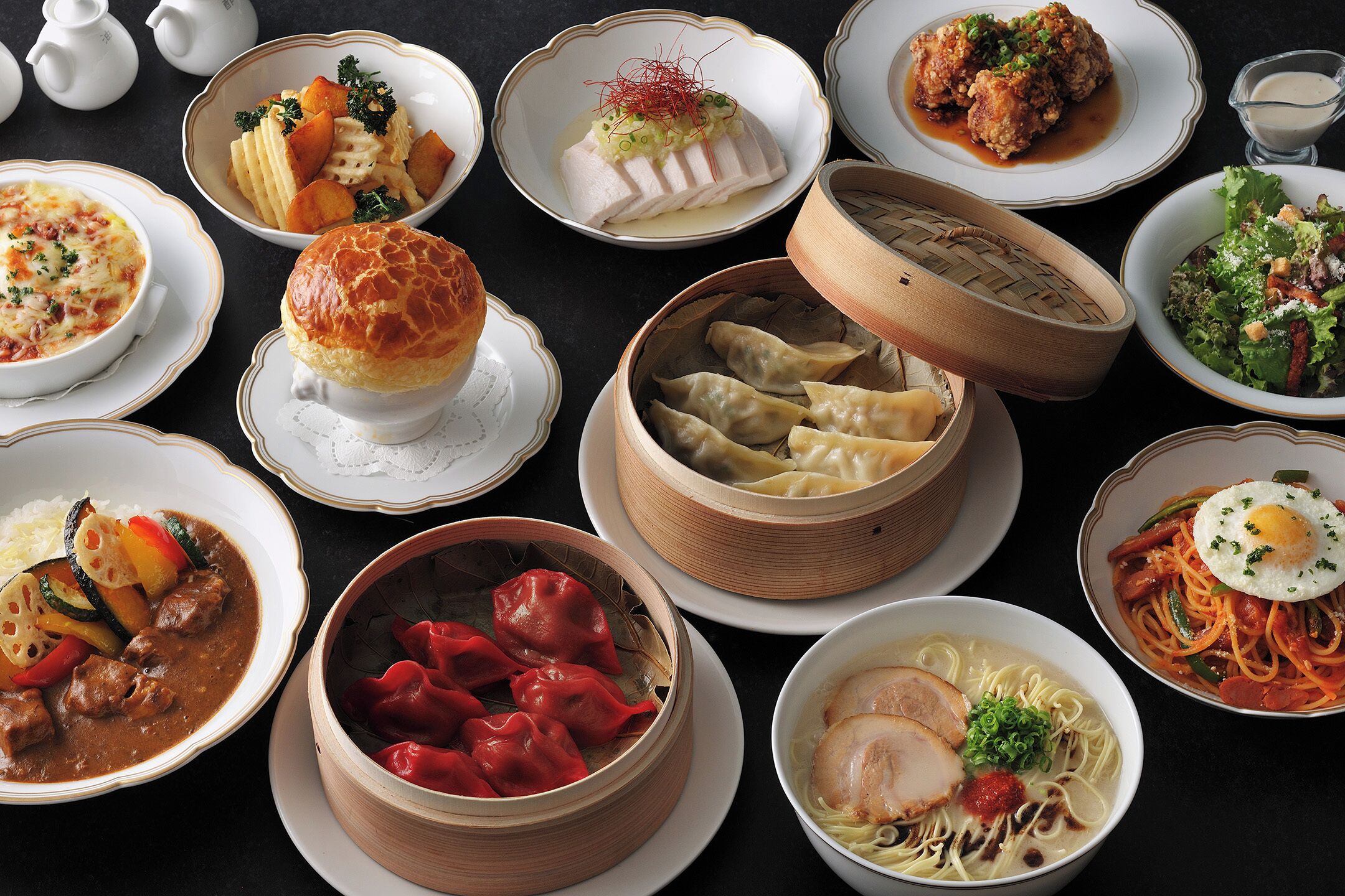 A variety of dishes including dumplings, noodles, and a soup, arranged on a table.