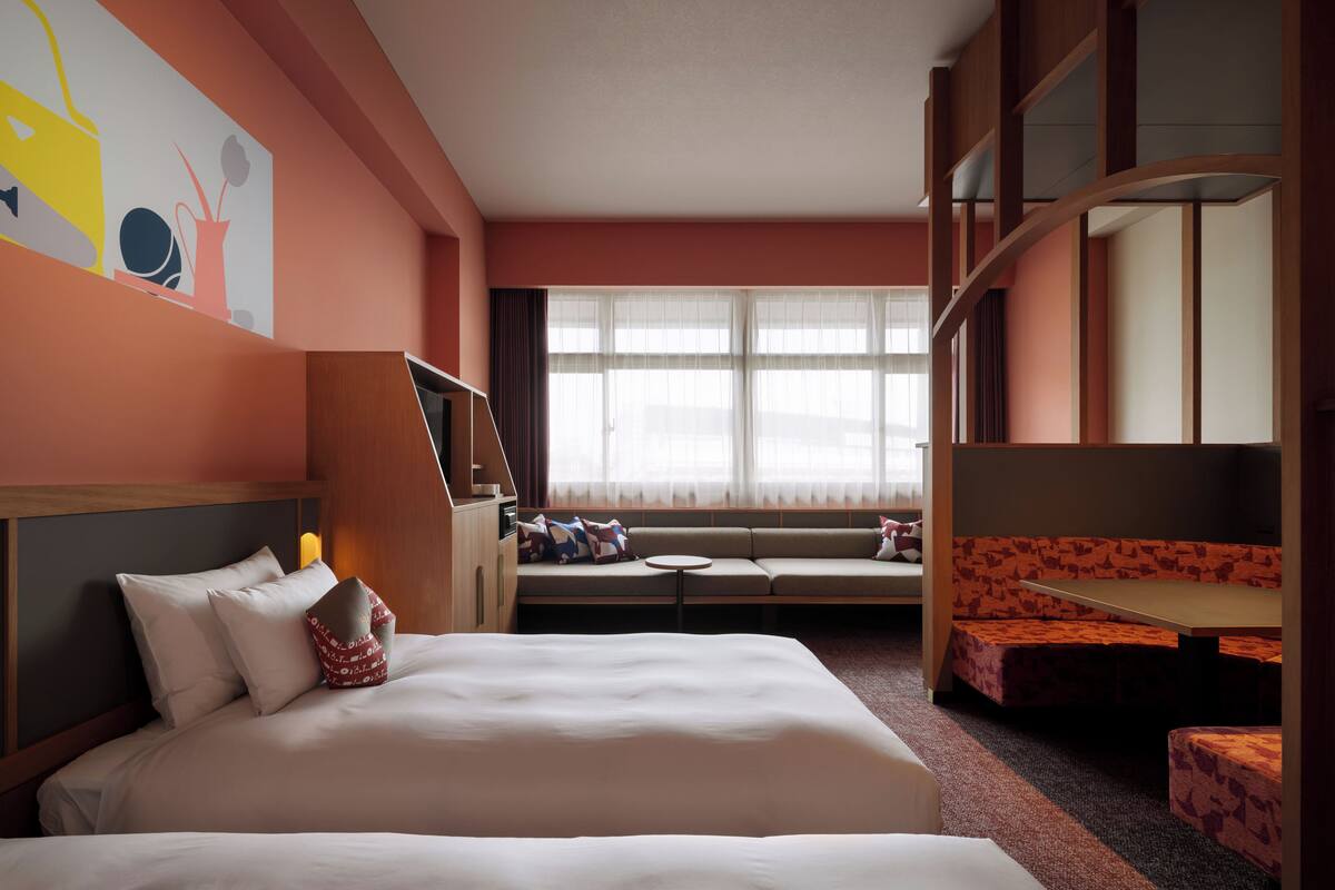 Une chambre d’hôtel avec un grand lit, un canapé, une petite table et un téléviseur.