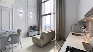 A modern living room with a sofa, TV, and dining area.