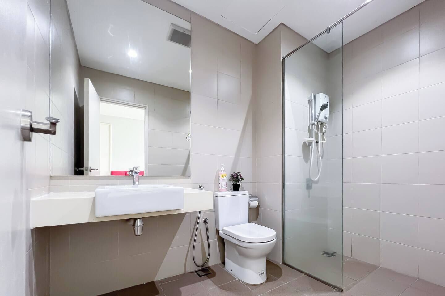 Une salle de bain moderne avec une douche à parois de verre, un lavabo blanc et des toilettes.