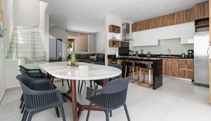 A modern kitchen with a central island, built-in cabinets, and a stainless steel refrigerator. - 3BR Family Villa Near Beach with Pool and Parking (Bucerías)