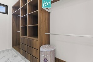 Ein begehbarer Kleiderschrank mit Holzböden und einem Mülleimer.