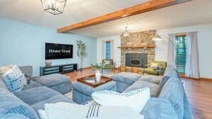 A living room with a stone fireplace, a flat-screen TV, and a large sofa set. - 6 Br Sleeps 20 I Sauna•Theater•Putt Putt•Hot Tub (Asheville)