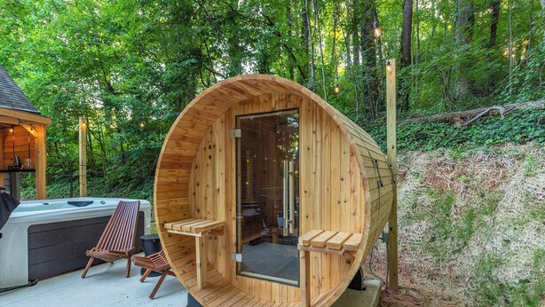 A wooden sauna with a curved roof, two wooden benches, and a glass door. - 6 Br Sleeps 20 I Sauna•Theater•Putt Putt•Hot Tub (Asheville)