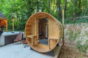 Una sauna de madera con techo curvo, dos bancos de madera y una puerta de vidrio.