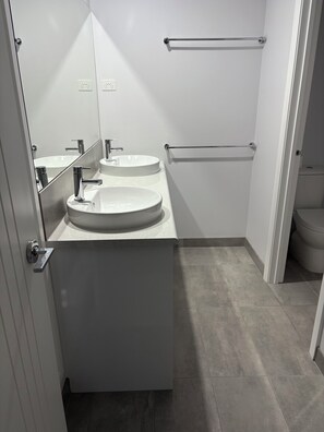 Een douche, handdoeken, zeep, toiletpapier