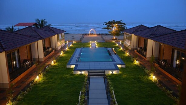 Un resort con piscina, vistas al océano y varias habitaciones de huéspedes.