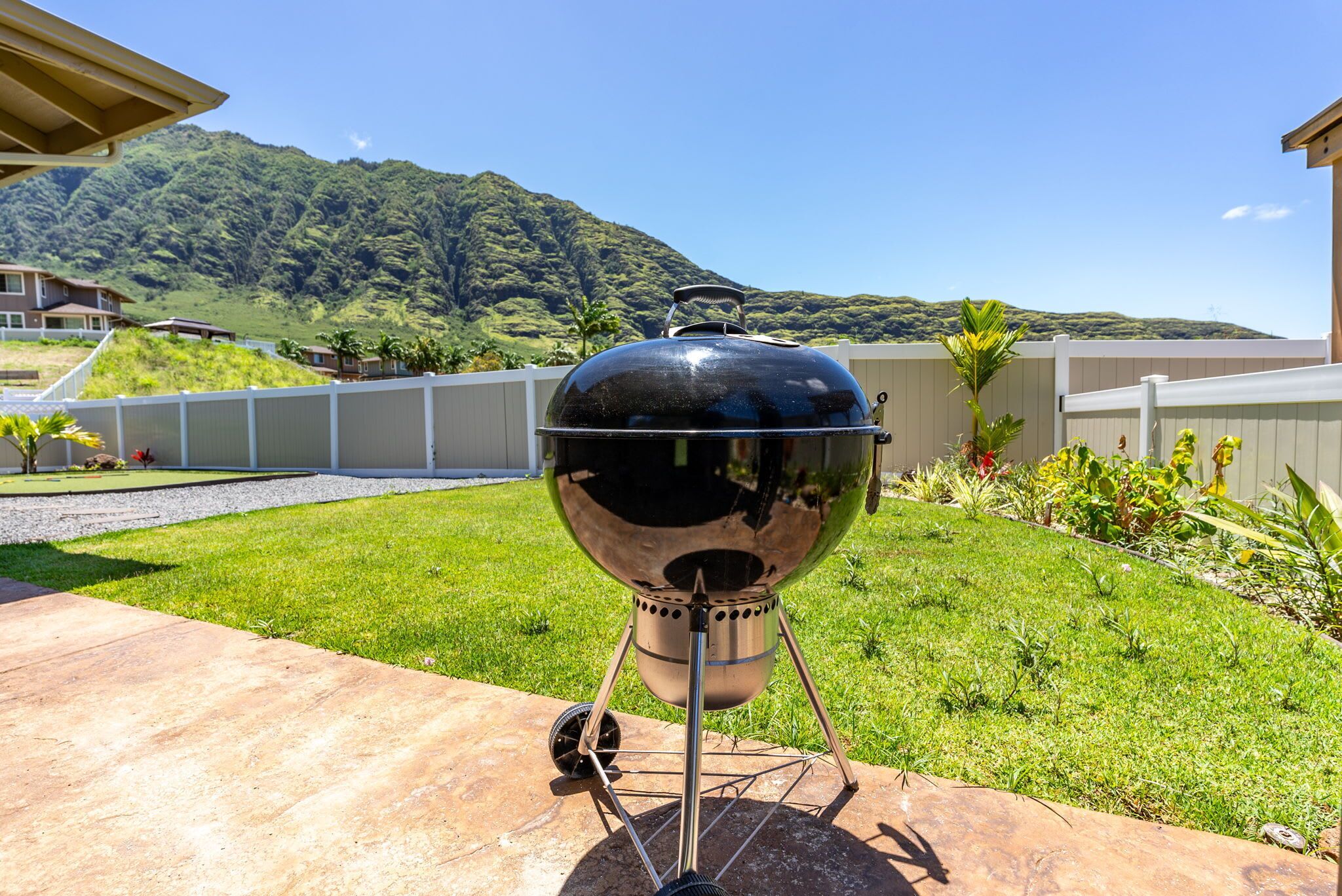 A barbecue grill in a backyard with a mountain view.