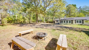 A backyard with a fire pit, two picnic tables, and a house in the background. - < 1 Mi to Lake: Secluded Ore City Getaway (Ore City)
