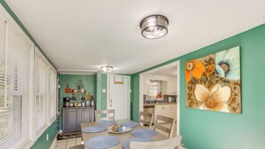 A dining area with a table set for four, a kitchen in the background, and a painting on the wall. - < 1 Mi to Lake: Secluded Ore City Getaway (Ore City)