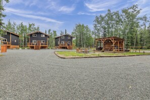 A resort with three cabins, each with a wooden deck and a small outdoor seating area. - Kenai River Retreat ~ 4 Mi to Morgan's Landing! (Sterling)